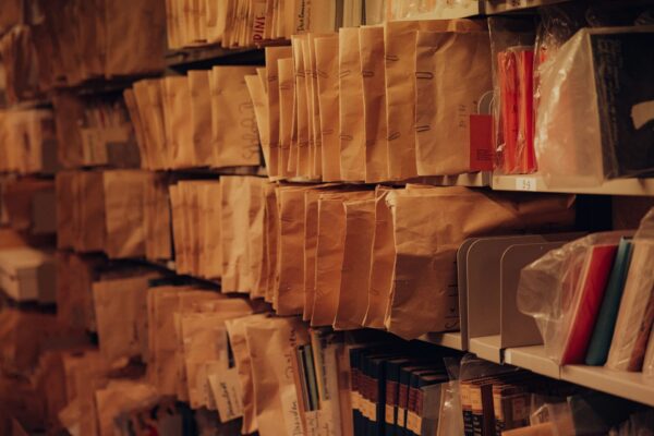 In Umschlägen archivierte Programmhefte in einem Regal